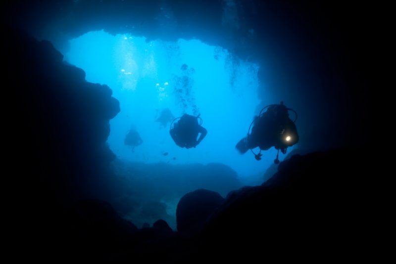 Cave divers diving into the Santa Maria Caves © ifish/iStock